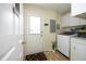 Well-lit laundry area with white washer and dryer, storage cabinets and exterior door at 38 Maple Cir, Pittsboro, NC 27312