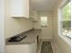 Bright laundry room features neutral colors, cabinetry, and a window providing natural light at 38 Maple Cir, Pittsboro, NC 27312