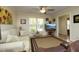 Comfortable living room featuring a ceiling fan, plush sofa, glass coffee table, and a large window with natural light at 38 Maple Cir, Pittsboro, NC 27312