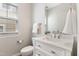 Well-lit half bathroom featuring a modern vanity, a sleek toilet, and neutral decor at 3811 Yates Mill Trail, Raleigh, NC 27606