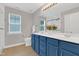 Bathroom with double sinks, shaker-style blue cabinets, and a large mirror at 3811 Yates Mill Trail, Raleigh, NC 27606