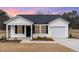 Charming single-story home with white siding, black shutters, and a well-maintained front yard at 385 Dasu Dr, Clayton, NC 27520