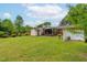 Large backyard featuring multiple sheds, manicured lawn, and a covered back porch at 3913 Vesta Dr, Raleigh, NC 27603