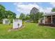 Expansive backyard featuring multiple outbuildings, a white fence, and lush green lawn at 3913 Vesta Dr, Raleigh, NC 27603