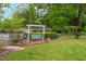 Backyard swing with landscaping and fountain in a lush green backyard with chain link fence at 3913 Vesta Dr, Raleigh, NC 27603