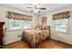 Cozy bedroom with hardwood floors, ceiling fan, and large windows at 3913 Vesta Dr, Raleigh, NC 27603