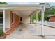 Spacious carport featuring a brick accent wall, providing convenient covered parking with access to back yard at 3913 Vesta Dr, Raleigh, NC 27603