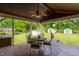 Covered wood deck with dining table and chairs, lush green lawn and fenced in backyard at 3913 Vesta Dr, Raleigh, NC 27603