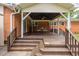 Backyard covered deck with brick home, wood stairs, railings, and dining furniture at 3913 Vesta Dr, Raleigh, NC 27603