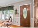 Inviting entryway featuring a decorative leaded glass door, wood floors, and large window with a rocking chair at 3913 Vesta Dr, Raleigh, NC 27603
