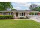 Inviting single-story home featuring a well-manicured lawn, covered carport, and classic brick and siding facade at 3913 Vesta Dr, Raleigh, NC 27603