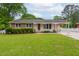 Charming single-story home featuring a well-manicured lawn, covered carport, and classic brick and siding facade at 3913 Vesta Dr, Raleigh, NC 27603