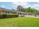 Well-maintained single-story home featuring a manicured lawn, brick accents, and mature trees in a serene setting at 3913 Vesta Dr, Raleigh, NC 27603