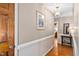 Hallway with wood flooring, picture frame, light fixture, and side table that leads into another room at 3913 Vesta Dr, Raleigh, NC 27603
