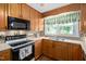 Close up of kitchen features including oak cabinets, an oven and cooktop, a window and a microwave at 3913 Vesta Dr, Raleigh, NC 27603