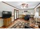 Bright living room featuring hardwood floors, French doors, and a large television for entertainment at 3913 Vesta Dr, Raleigh, NC 27603