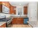 Close-up of kitchen with granite countertops, stainless steel appliances, and dark wood cabinets at 3917 White Kestrel Dr, Raleigh, NC 27616