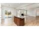 View of open floor plan of great room and kitchen with wood floors, kitchen island, and lots of light at 3917 White Kestrel Dr, Raleigh, NC 27616