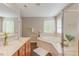 Bright bathroom featuring double sink vanity, soaking tub, and tiled surround at 413 Palafox Dr, Chapel Hill, NC 27516