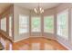 Bright dining area featuring hardwood floors, abundant natural light from large windows, and a classic chandelier at 413 Palafox Dr, Chapel Hill, NC 27516