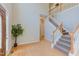Bright foyer with hardwood floors, a staircase with white rails, and a decorative houseplant at 413 Palafox Dr, Chapel Hill, NC 27516