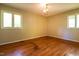 Cozy bedroom with hardwood floors, a classic chandelier, and windows for natural light at 416 Colony Woods Dr, Chapel Hill, NC 27517