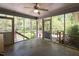 Enclosed porch with concrete flooring, fan, and views of the surrounding backyard landscape at 416 Colony Woods Dr, Chapel Hill, NC 27517