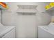 Well-lit laundry area with white shelving and washer and dryer hookups at 42 Riverwalk Ter, Durham, NC 27704