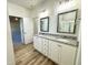 Bathroom featuring a granite countertop double vanity and wood-look floors, adjacent to shower at 427 Earnest Way # L24, Kenly, NC 27542