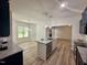 Well-lit kitchen featuring a central island, granite countertops, and hardwood floors at 427 Earnest Way # L24, Kenly, NC 27542
