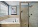 Bright primary bathroom features soaking tub and tiled walk-in shower with glass door at 429 Gambit Cir, Wake Forest, NC 27587