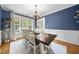 Dining room with large windows, elegant chandelier and wooden dining table at 429 Gambit Cir, Wake Forest, NC 27587