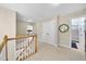 Light-filled second floor hallway with neutral walls and carpet, doors, and staircase at 429 Gambit Cir, Wake Forest, NC 27587