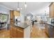 Open-concept kitchen with granite island, hardwood floors, stainless appliances, seamlessly connected to dining and living areas at 429 Gambit Cir, Wake Forest, NC 27587