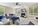Bright living room features a fireplace, large windows, and cozy seating, creating an inviting atmosphere for gatherings at 429 Gambit Cir, Wake Forest, NC 27587
