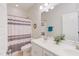 Bright bathroom with double sinks, decorative mirror, white sink, and patterned shower curtain at 43 Turtle Point Bnd, Chapel Hill, NC 27516