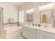 Bathroom featuring double sinks, marble countertops, soaking tub with tile surround and mosaic accents at 43 Turtle Point Bnd, Chapel Hill, NC 27516