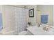 Cozy bathroom with shower/tub combo, decorative mirror, white sink, and patterned shower curtain at 43 Turtle Point Bnd, Chapel Hill, NC 27516