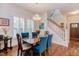 Bright dining room featuring hardwood floors, chandelier, and staircase view with custom window shutters at 43 Turtle Point Bnd, Chapel Hill, NC 27516