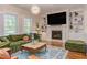 Living room with hardwood floors, a large sectional sofa, custom built-ins, a fireplace, and a mounted TV at 43 Turtle Point Bnd, Chapel Hill, NC 27516
