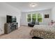 Bright bedroom boasts large windows, a cozy couch, and a stylish entertainment center at 433 Wait Ave # 100, Wake Forest, NC 27587