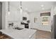 Bright kitchen featuring white cabinets, granite countertops, stainless steel appliances, and a stylish pendant light at 437 Providence Springs Ln, Fuquay Varina, NC 27526