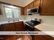 Modern kitchen featuring stainless steel appliances, wood cabinetry, and ample counter space at 4420 Beechnut Ln, Durham, NC 27707