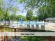 Community pool with lounge chairs and umbrellas on a sunny day at 4420 Beechnut Ln, Durham, NC 27707