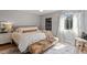 Well-lit bedroom showcases a comfortable bed, stylish bench, and sunlight from a window at 4507 Edwards Mill Rd # F, Raleigh, NC 27612