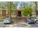 Brick building with parking lot, mature trees, and stairwell entrance at 4507 Edwards Mill Rd # F, Raleigh, NC 27612