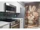 Updated kitchen showcasing stainless appliances, white cabinets, and decorative backsplash at 4507 Edwards Mill Rd # F, Raleigh, NC 27612