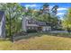 Well-maintained two-story home with a combination of siding and brick, surrounded by mature trees and a green lawn at 5315 Oakbrook Dr, Durham, NC 27713