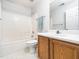 This clean bathroom includes a shower-tub combo, white tile, and a wooden vanity at 5504 Cumberland Plain Dr, Raleigh, NC 27616