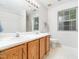Bright bathroom with dual sinks, wood vanity, large mirror and natural light at 5504 Cumberland Plain Dr, Raleigh, NC 27616